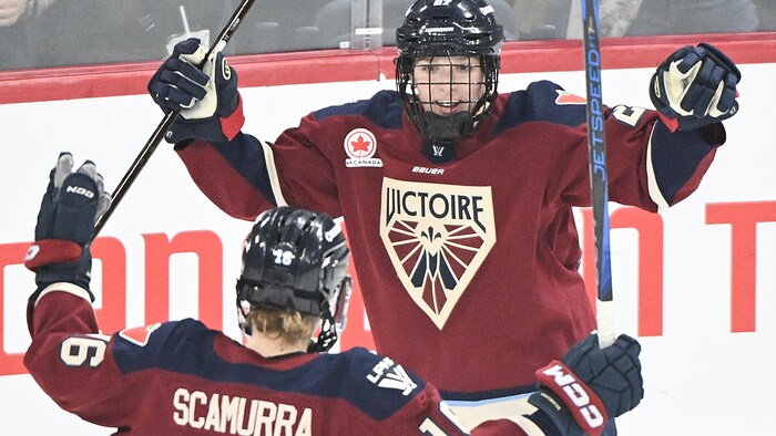 Deux joueuses de hockey célèbrent un but.