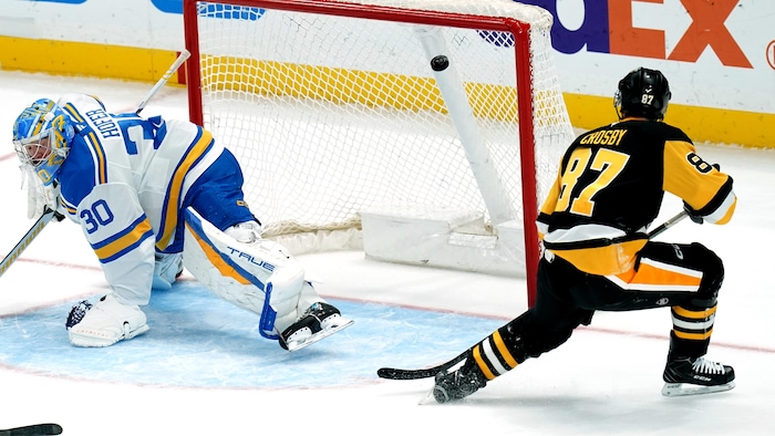 Un joueur de hockey déjoue un gardien. 