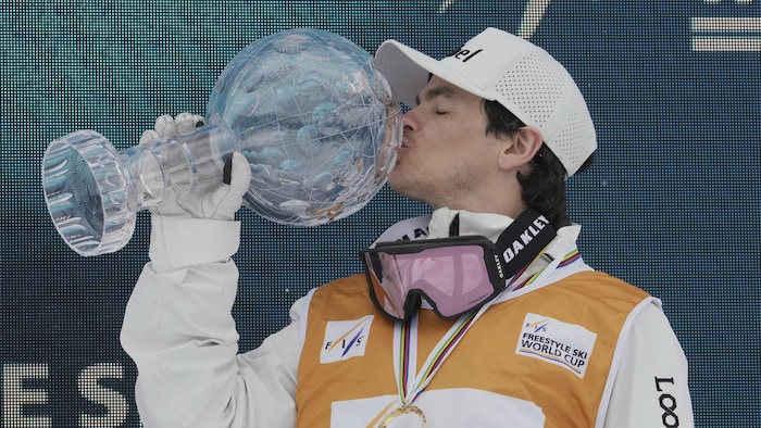 Un homme embrasse son globe de cristal.