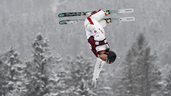 Un skieur acrobatique effectue un saut.