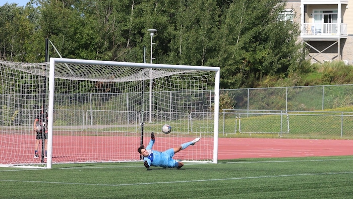 Gardien de but plongeant.