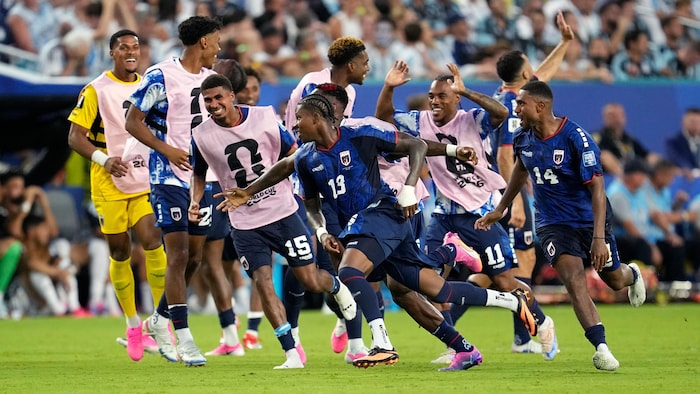 Un joueur de soccer court avec ses coéquipiers pour célébrer un but.