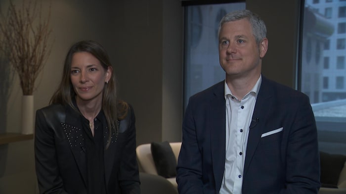 Ils regardent devant eux pendant une entrevue à la caméra.