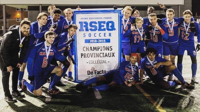 Les joueurs posent pour la caméra en tenant une affiche annonçant qu'ils sont les champions provinciaux.