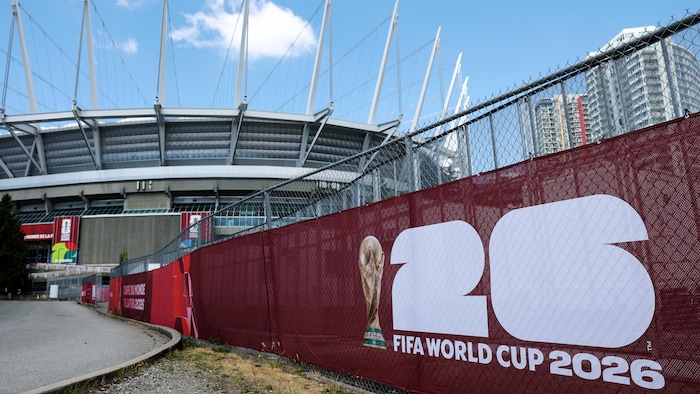 Une affiche aux couleurs de la Coupe du monde apparaît sur une clôture qui longe le stade.