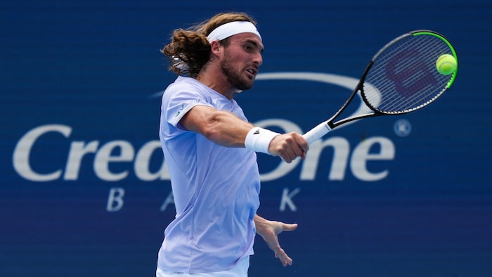 Un joueur de tennis frappe un revers.