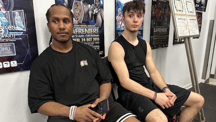 Ils sont assis sur des chaises dans un gym de boxe.