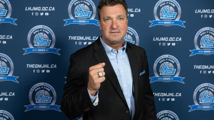 Un ancien joueur de hockey montre sa bague de la LHJMQ.
