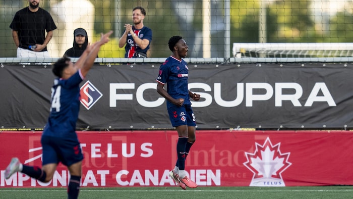 Deux joueurs de soccer célèbrent un but.