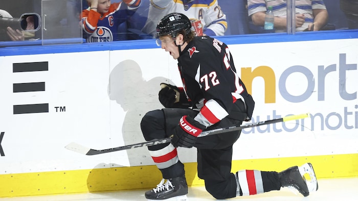 Un joueur célèbre un but sur la glace, au hockey.