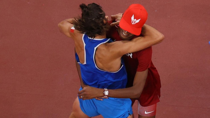 Deux athlètes se serrent dans leurs bras.