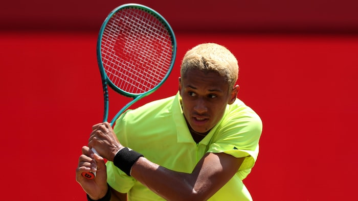 Un joueur de tennis effectue un coup du revers.