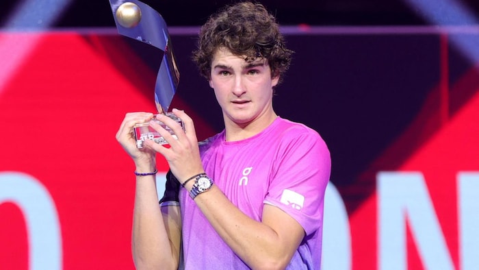 Il tient lad trophée determination la photo.