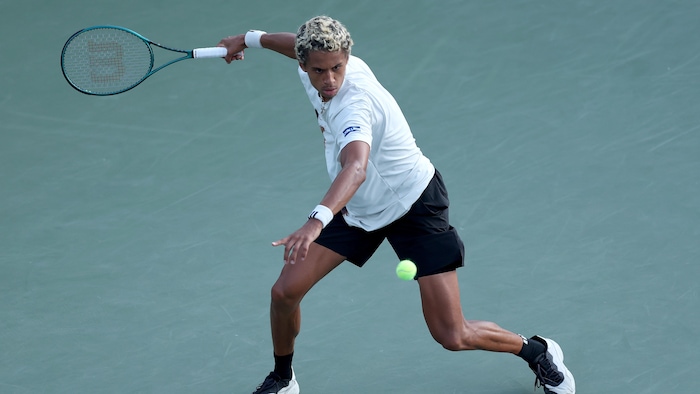 Un joueur de tennis s'apprête à frapper la balle d'un coup droit.