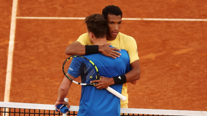 Félix Auger-Aliassime et Jiri Lehecka s'enlacent au-dessus du filet du terrain de tennis.
