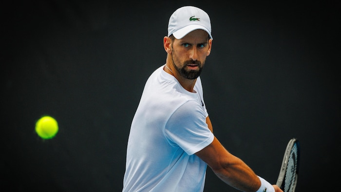 Un joueur de tennis s'apprête à frapper une balle du revers.