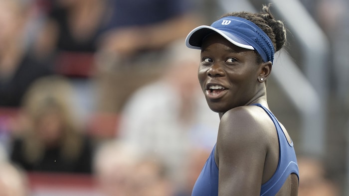 Une joueuse de tennis regarde au loin.