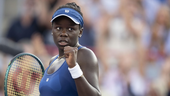 Une joueuse de tennis lève le poing gauche.