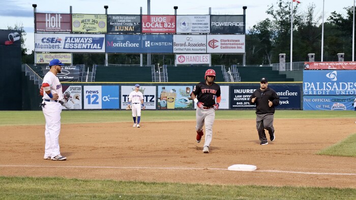 Un joueur de baseball court sur les sentiers.