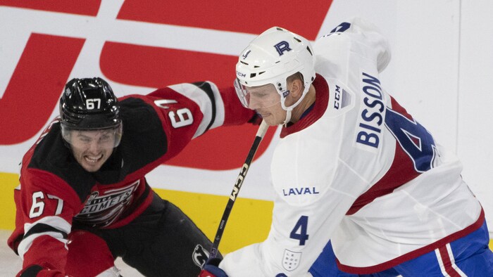 Le joueur du Rocket effectue un lancer devant un adversaire qui tente de le contrer. 
