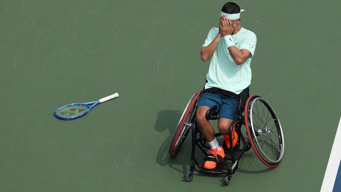 Ému, il se couvre le visage avec ses mains.