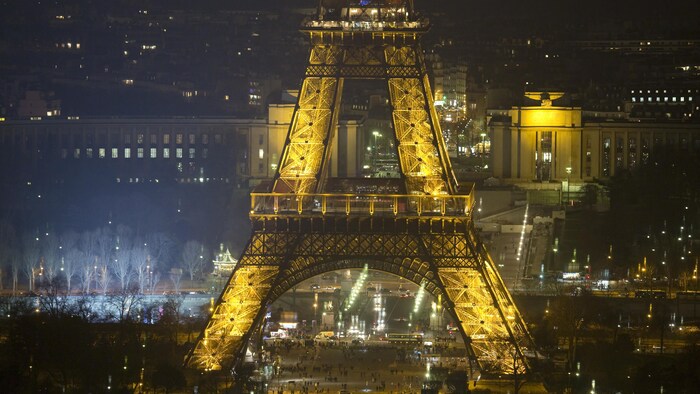 La tour Eiffel est éclairée dans la nuit parisienne.