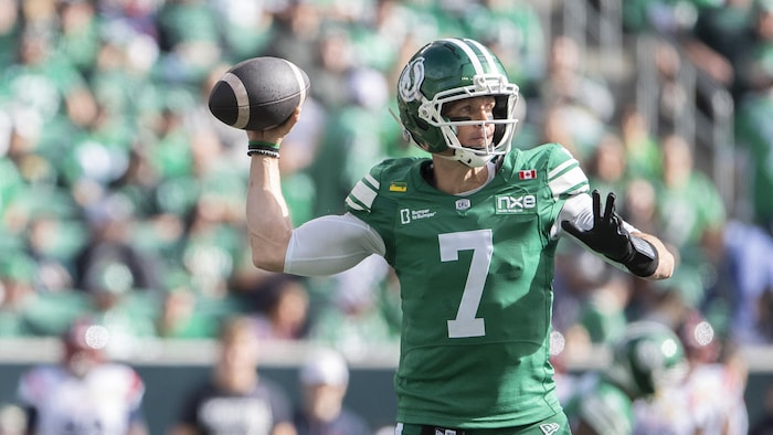 Un joueur de football lance le ballon. 