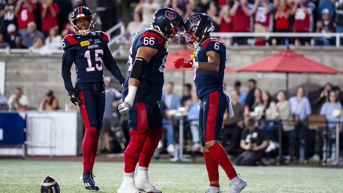 Des joueurs de football célèbrent un touché.