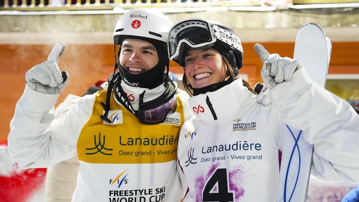 Deux athlètes sourient après leur victoire.
