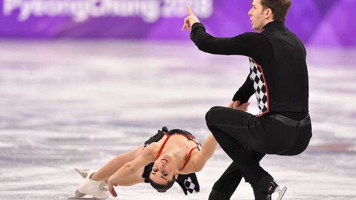 Le patineur fait tournoyer sa partenaire pendant un programme.