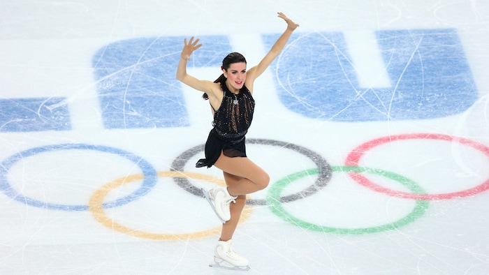 Elle lève les bras dans les airs pendant son programme.