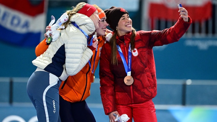 Des patineuses se font un égoportrait après avoir reçu leur médaille.