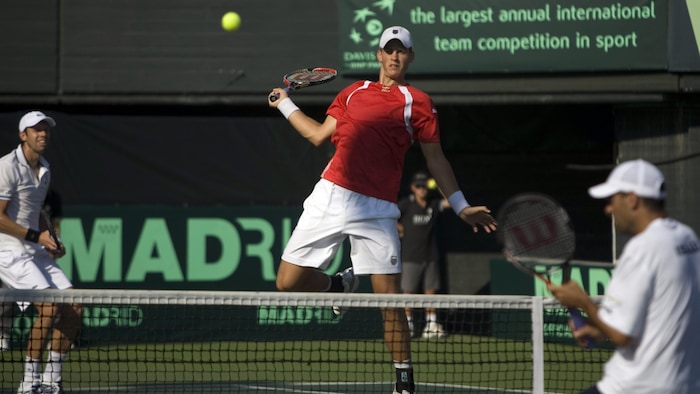 Un joueur de tennis saute pour effectuer une frappe au filet.