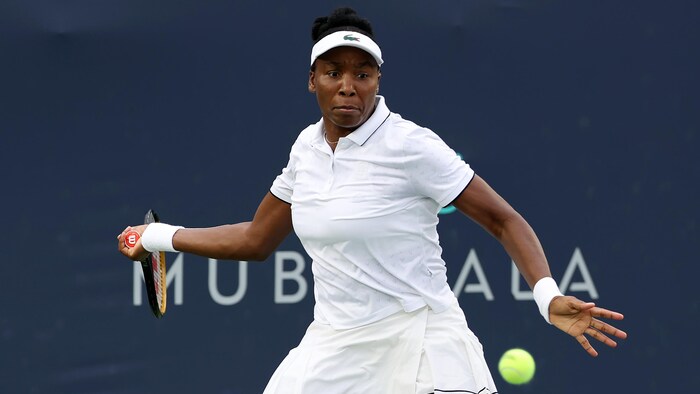 Une joueuse de tennis s'apprête à frapper un coup droit.