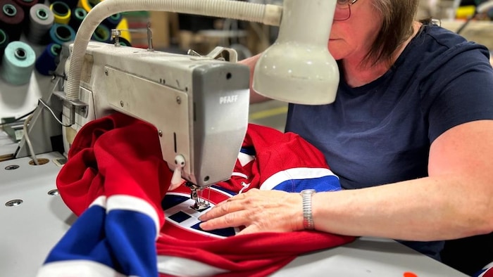 Une femme passe un chandail du Canadien de Montréal à la machine à coudre.