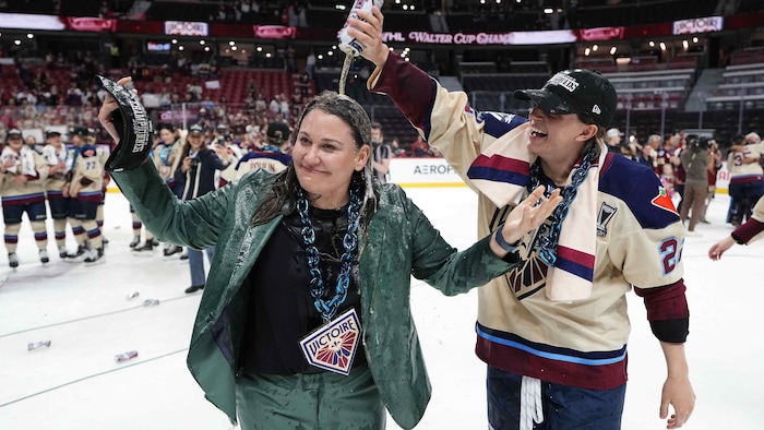 Une joueuse de hockey arrose son entraîneuse d'alcool après la victoire d'un championnat. 