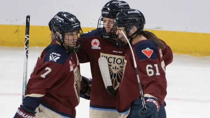 Des joueuses de hockey célèbrent un but.