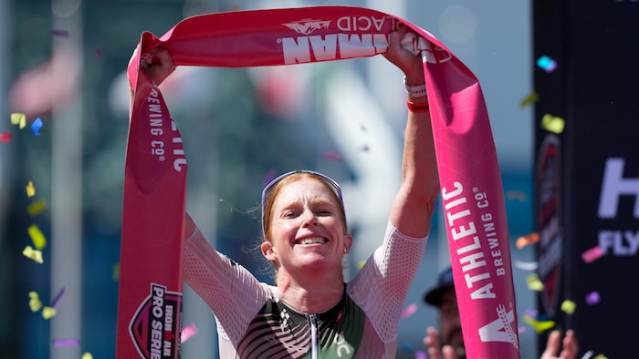 Une femme qui lève une banderole dans les airs après une victoire.