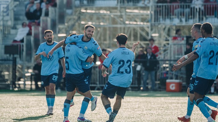 Joueurs de soccer se félicitent.