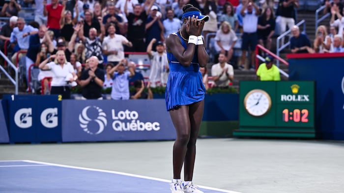 Une joueuse de tennis devant la foule, les mains dans le visage.