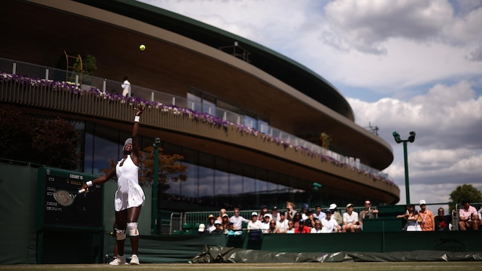 Une joueuse de tennis au service.