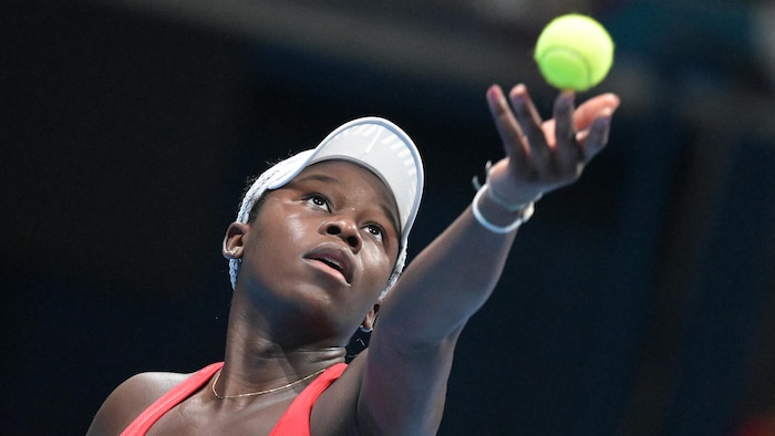 Une joueuse de tennis se prépare à servir.