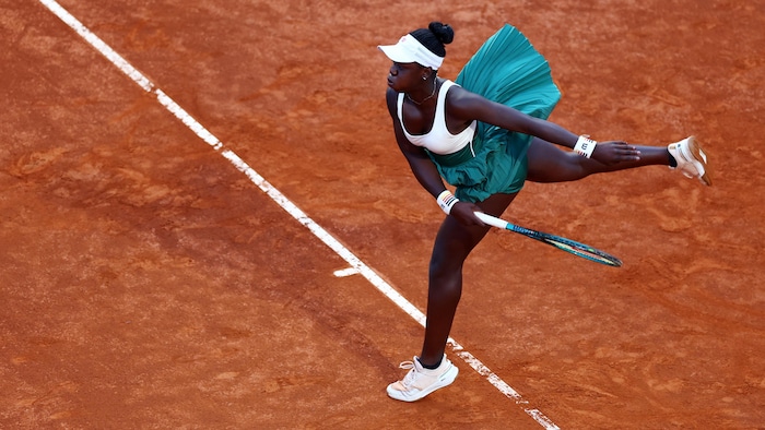 La joueuse de tennis effectue un work pendant un lucifer disputé sur terre battue.