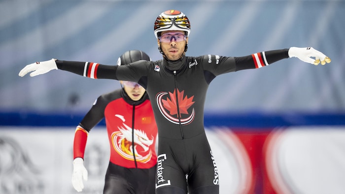 Un patineur de vitesse célèbre sa victoire.