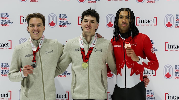 Des hommes célèbrent leur médaille.