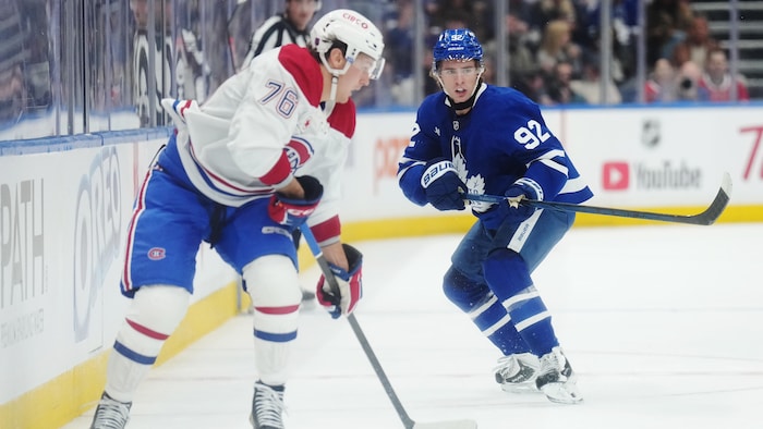 Deux adversaires au hockey se disputent la rondelle.