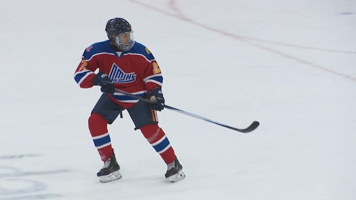 Zyon Decaens est sur la glace, avec son équipe de hockey, il attend la rondelle et regarde au loin.