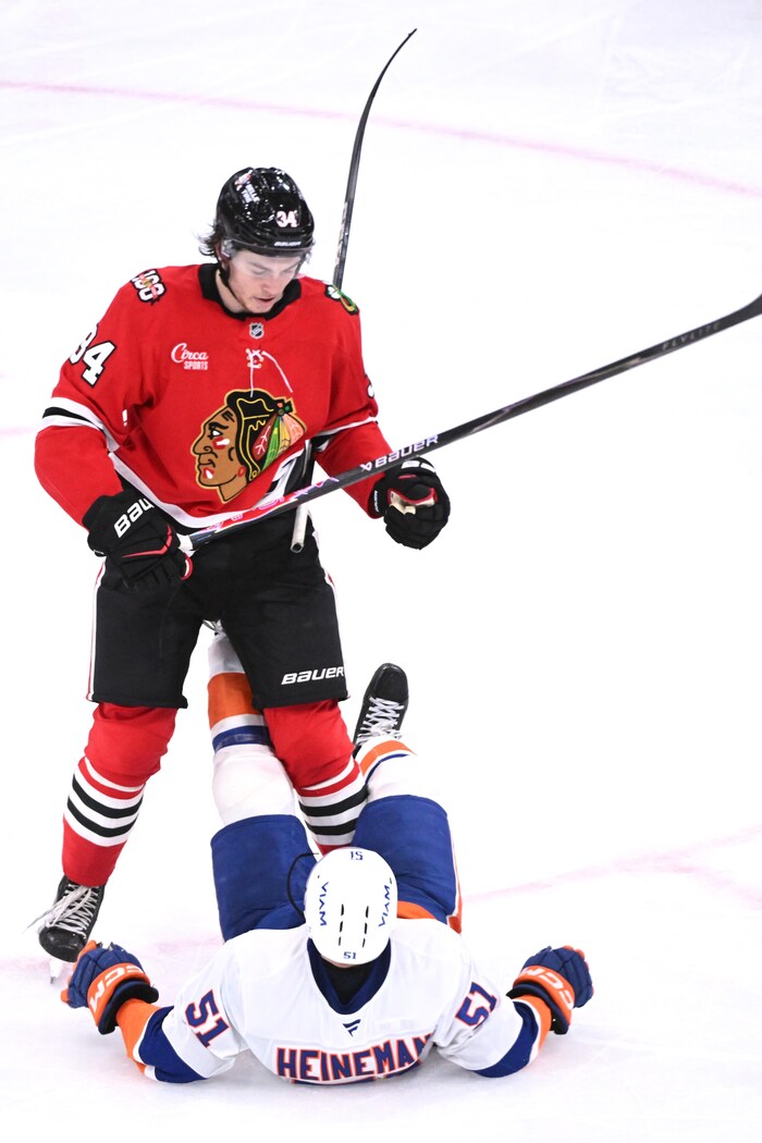 Colton Dach met un joueur des islanders en échec lors d'un match.