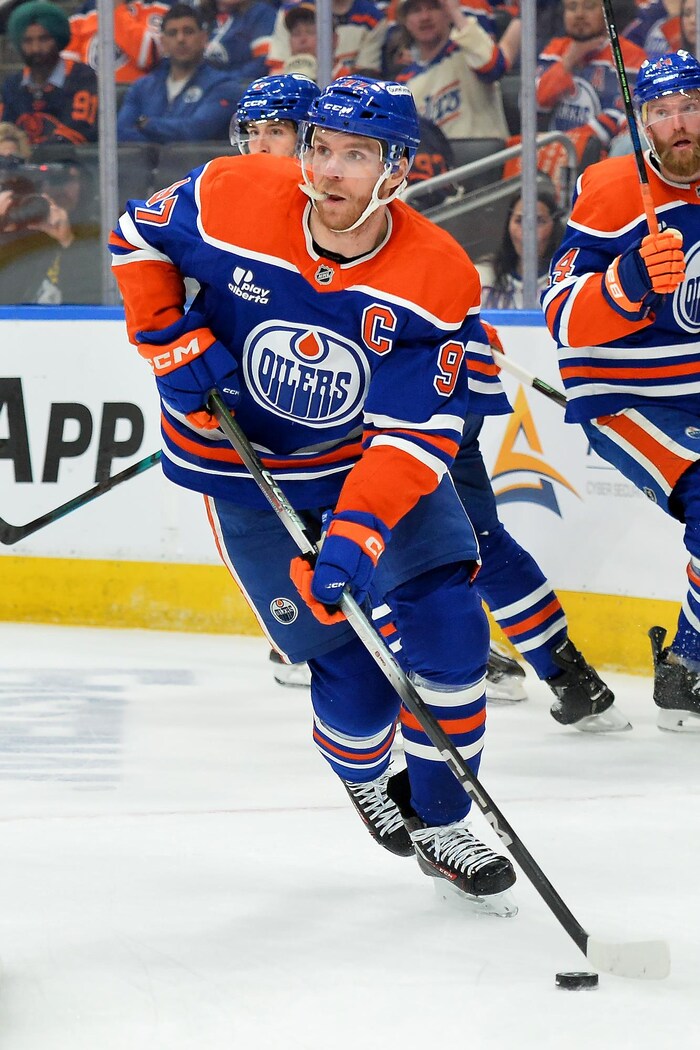 Connor McDavid patine avec la rondelle derrière son but. 