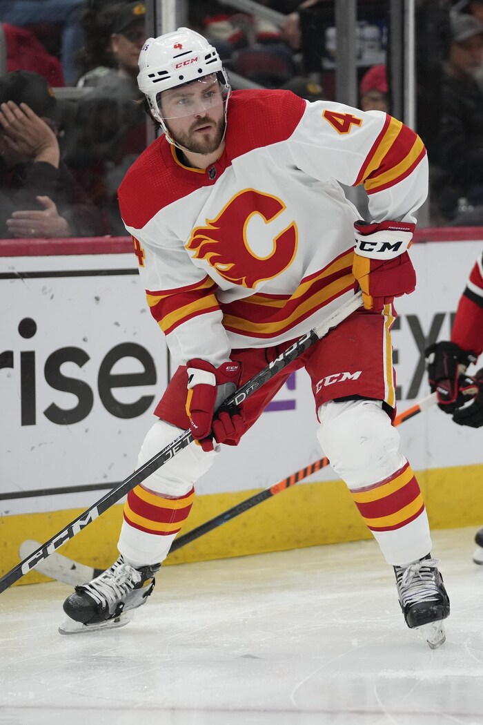 Un hockeyeur contrôle la rondelle devant un adversaire.